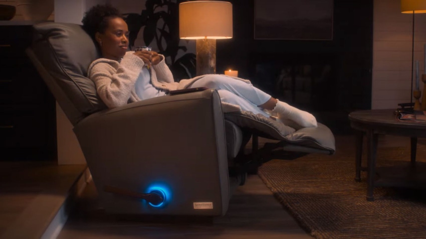 A woman sat on the La-Z-Boy Decliner chair. The Decliner uses AI to generate automatic responses via text so users can cancel plans guilt-free