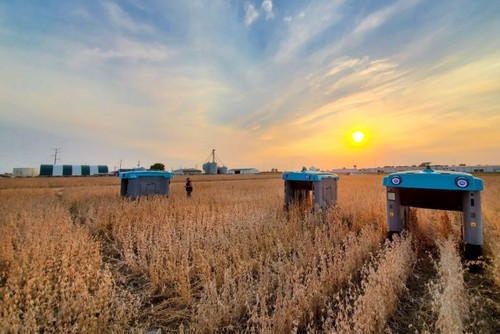 Photo of a field with agricultural machines on it 