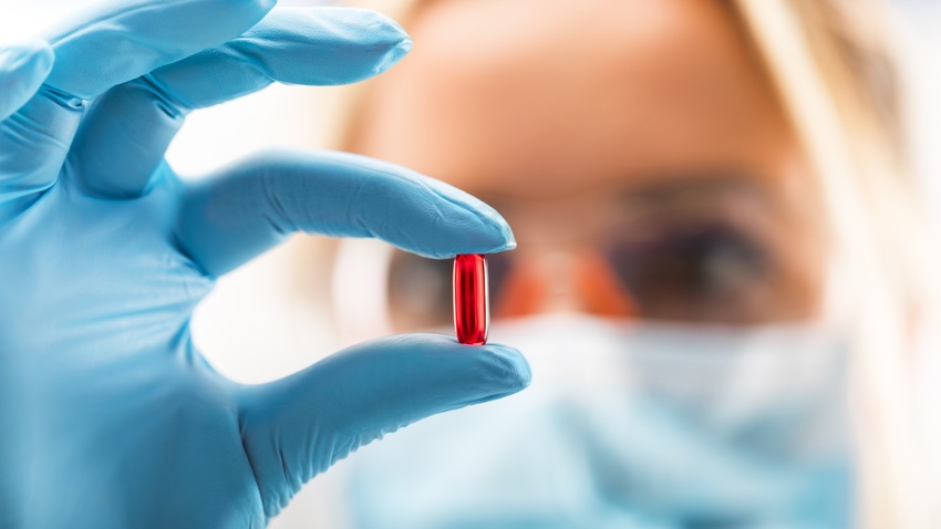 woman holding a pill woman holding a pill