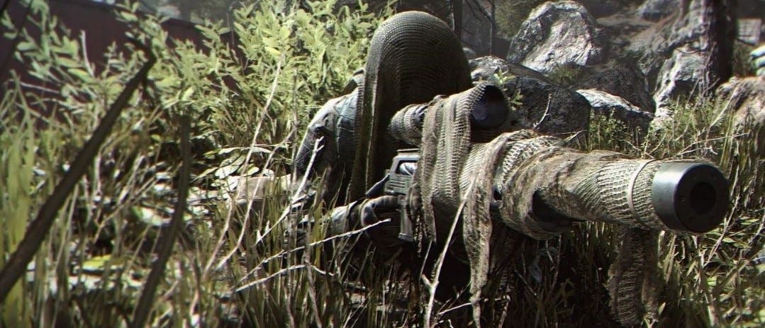 Sniper looking through lens of rifle in the jungle