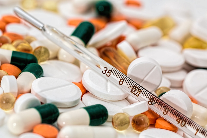 A stock image of a thermometer resting on a variety of medical pills A stock image of a thermometer resting on a variety of medical pills