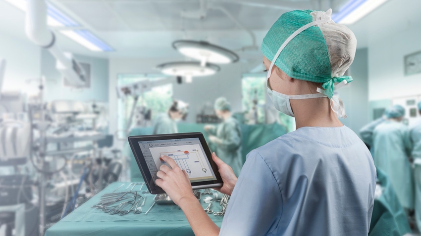 Surgeon looking at an iPad in an operating room