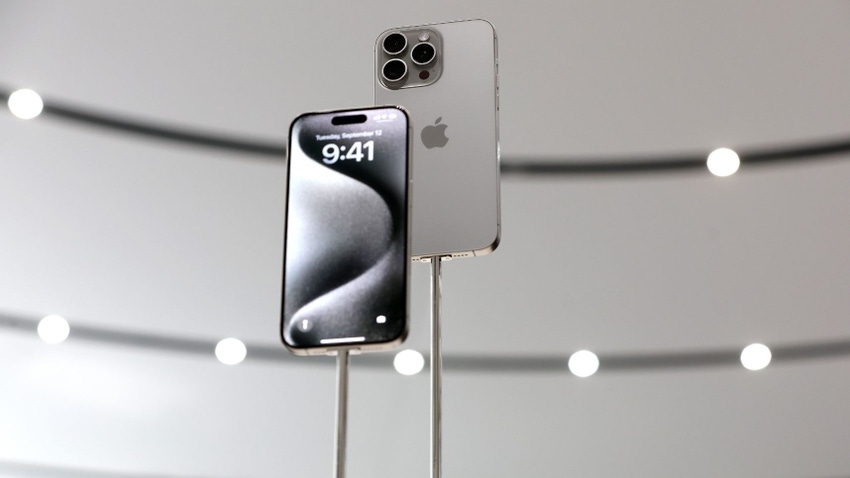 Two grey iPhones held aloft. One is facing forward, the other backwards atop a grey background