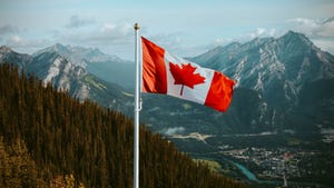 Canadian flag with mountain and small town views in summer