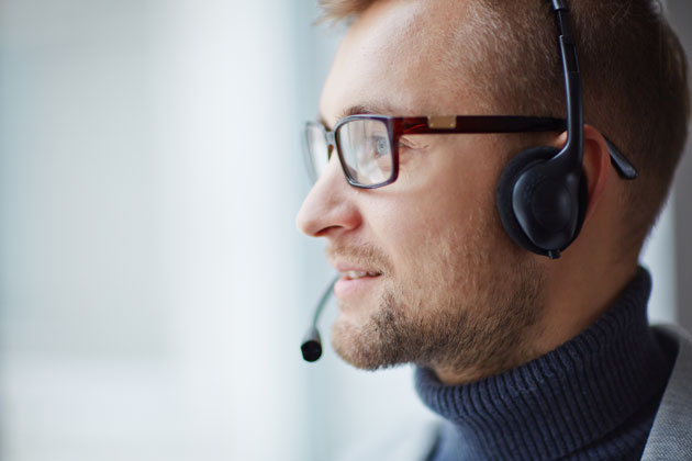 Photograph of head of man wearing a headset to answer calls