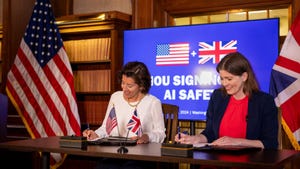 Michelle Donelan and Secretary of Commerce Gina Raimondo sign an agreement which will see them work together to develop tests for AI models