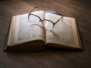 A stock photo of a pair of glasses on top of an open book 