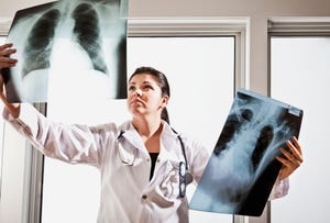 A woman physician examines X-rays