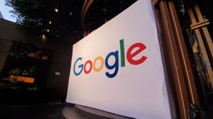 Wide angle of large conference display with logo for Google Inc at night