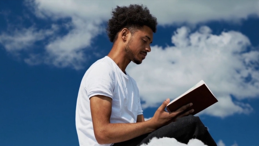 Image of a person reading a book in the clouds