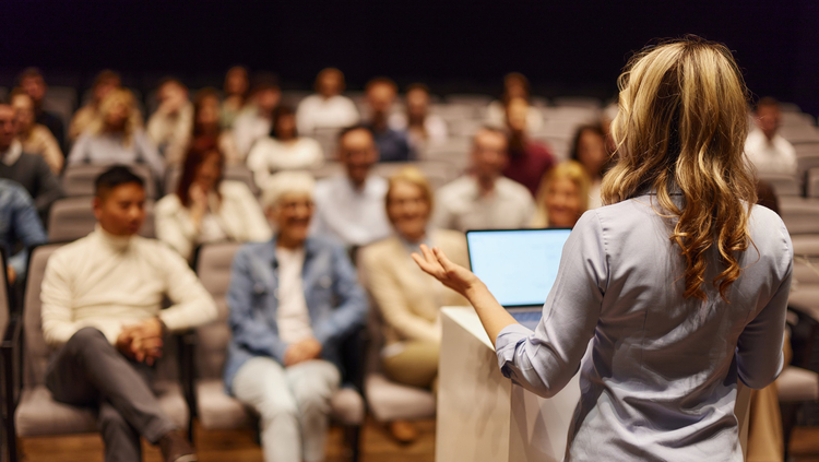 Conference audience listening to a presentation at a healthcare education event.