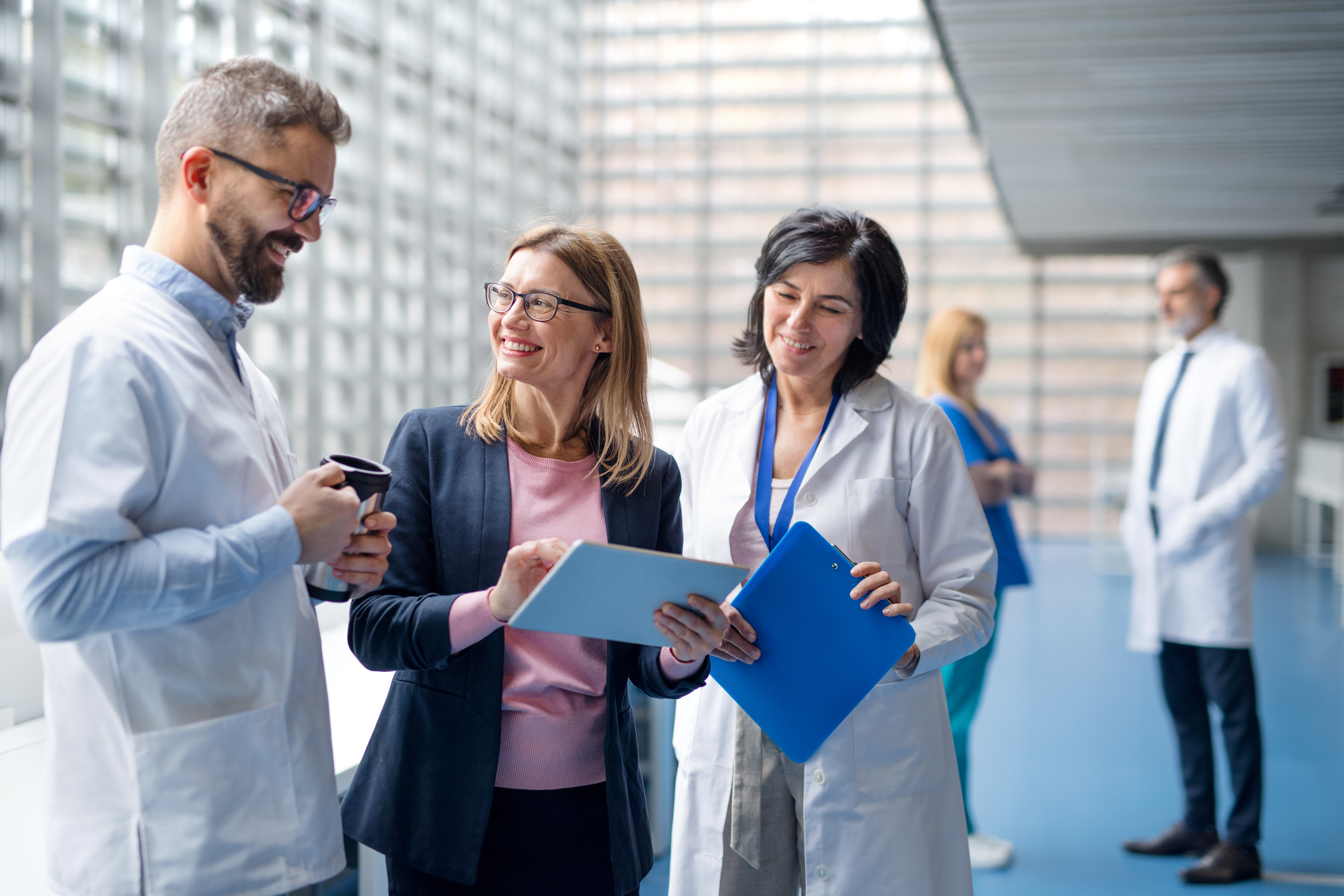 Healthcare professionals and a business colleague reviewing information together in a  healthcare facility