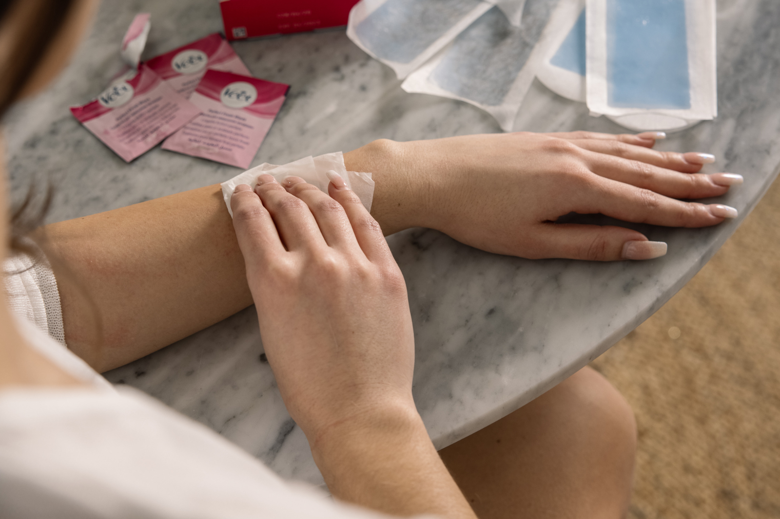 Woman using the Veet wipes after waxing her arm