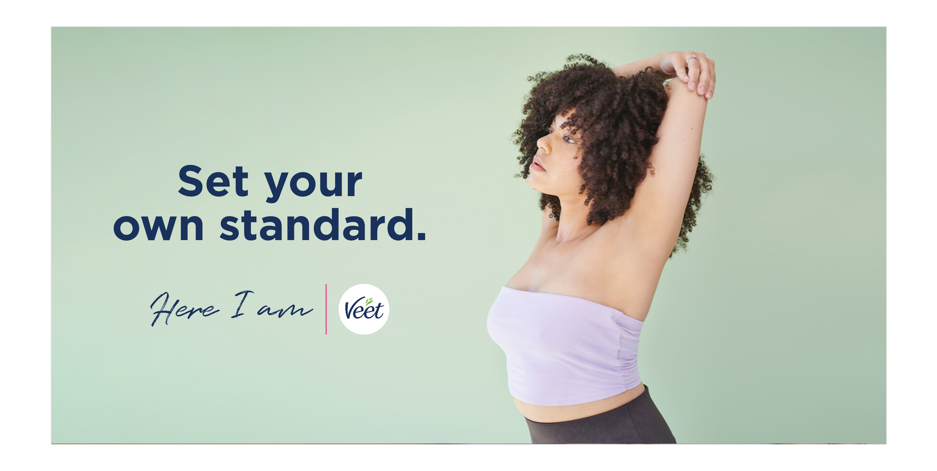Girl in a tube top stretching her hand over her head showing underarm with "Set your own standard." copy, and Here I am and Veet logo