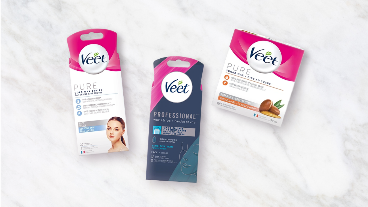 Trois produits dépilatoires Veet posés sur un comptoir en marbre.