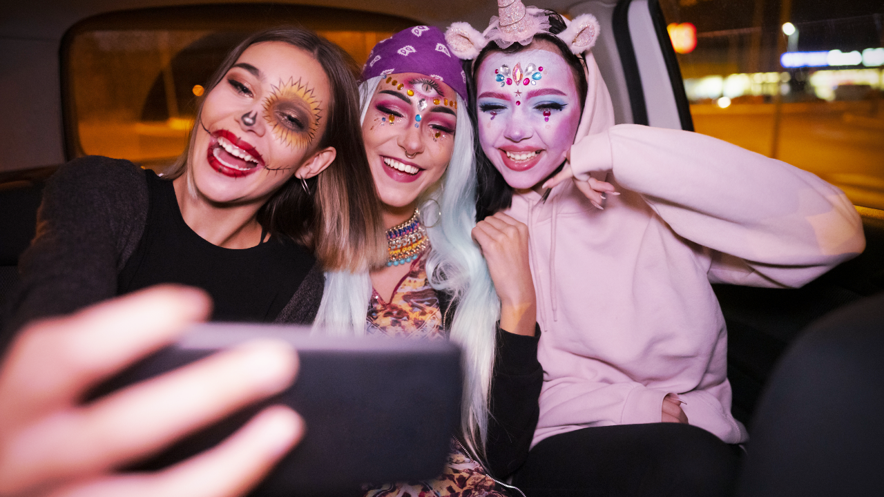 Three women dressed up for Halloween are taking a selfie together.