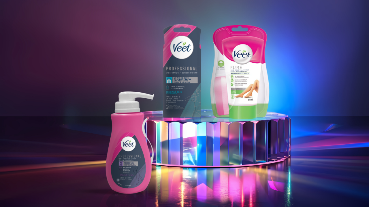 Veet® Professional and Pure hair removal products are displayed on a reflective surface with vibrant lighting.