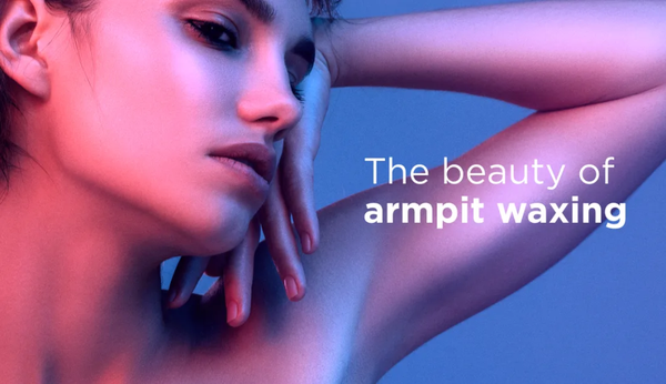 A radiant muscular woman holding her hand by her face, happy with her armpit waxing results.