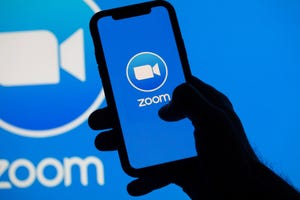 Zoom video conference app icon on a mobile device and desktop screen