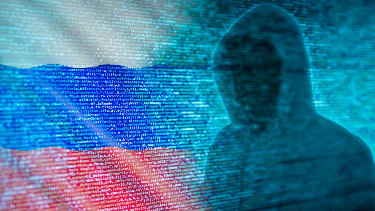 プログラムコードとロシア国旗の前に立つハッカーのシルエット プログラムコードとロシア国旗の前に立つハッカーのシルエット