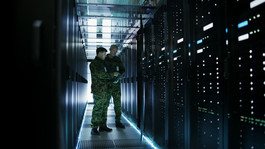 two men in military fatigues in a data center