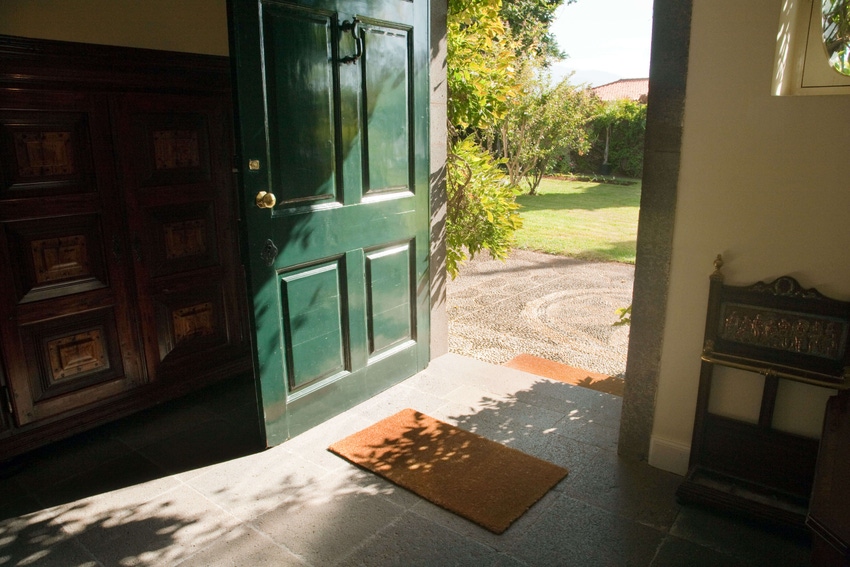 Photo of a door left wide open, looking out from the foyer to the garden