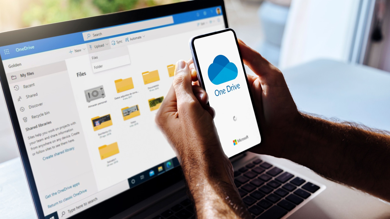 OneDriveのロゴが表示された携帯電話とコンピュータ OneDriveのロゴが表示された携帯電話とコンピュータ