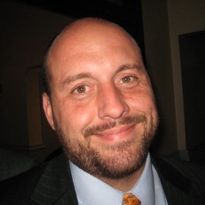 Steve Shelton has very short brown hair, beard, and mustache, and brown eyes. He's wearing a suit and tie, smiling. Steve Shelton has very short brown hair, beard, and mustache, and brown eyes. He's wearing a suit and tie, smiling.