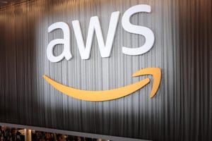 Photo of the AWS logo with the Amazon smile underneath posted high on a wall