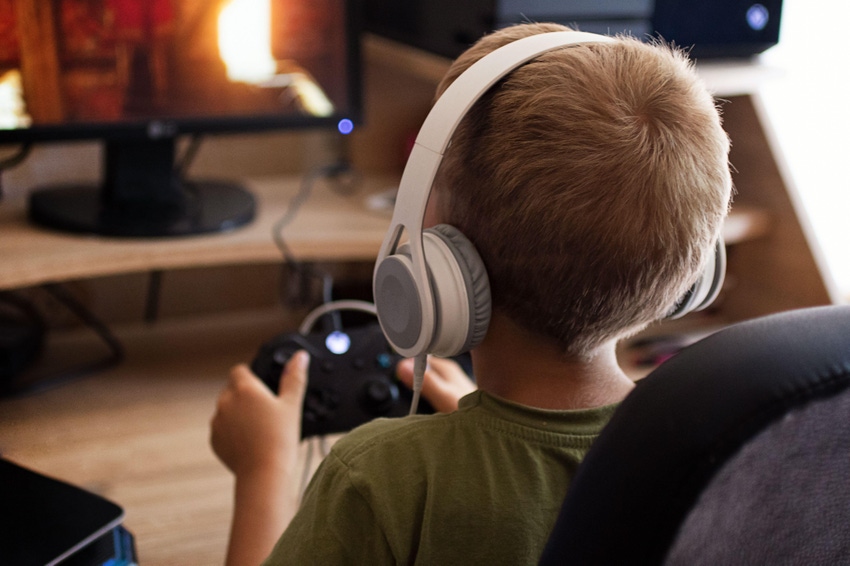 Boy playing Xbox with headphone on