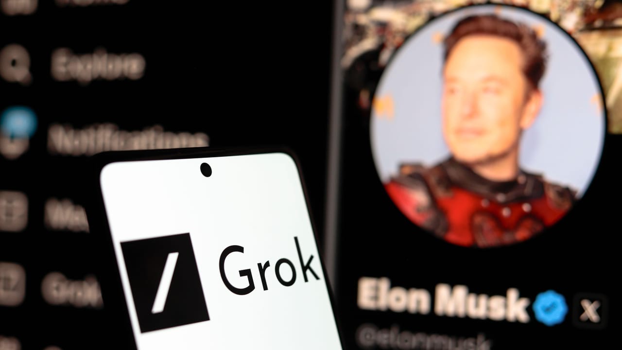 スマートフォンの画面に表示されたGrokのロゴ、その背後にイーロン・マスクのXプロフィールが表示されたコンピュータ画面 スマートフォンの画面に表示されたGrokのロゴ、その背後にイーロン・マスクのXプロフィールが表示されたコンピュータ画面