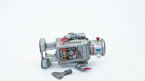 A toy robot laid on its side with its wind-up key in front of it. A toy robot laid on its side with its wind-up key in front of it.