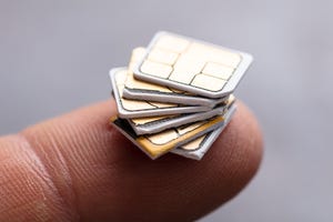A finger with five SIM cards balanced on the tip