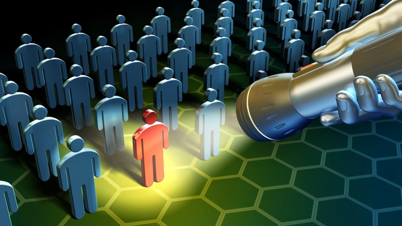 A silhouette of one person in red in rows of other people, with a flashlight shining on that person. A silhouette of one person in red in rows of other people, with a flashlight shining on that person.