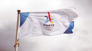 A Paris 2024 Olympics flag on a flag pole