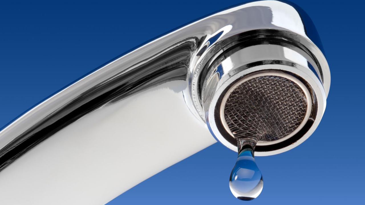 Water spigot with a drop coming out against blue background Water spigot with a drop coming out against blue background