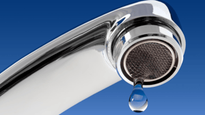 Water spigot with a drop coming out against blue background Water spigot with a drop coming out against blue background