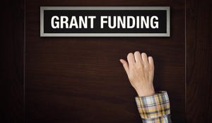 Hand knocking on a door that reads "GRANT FUNDING"