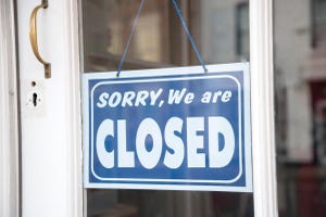 A blue and white sign on a window that reads, "Sorry, We Are Closed"