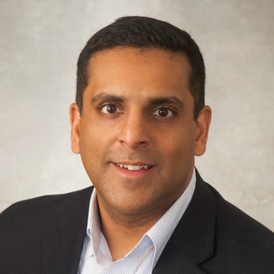Sanjay Raja, VP of Product Marketing and Solutions at Gurucul, has short black hair and a nice black suit