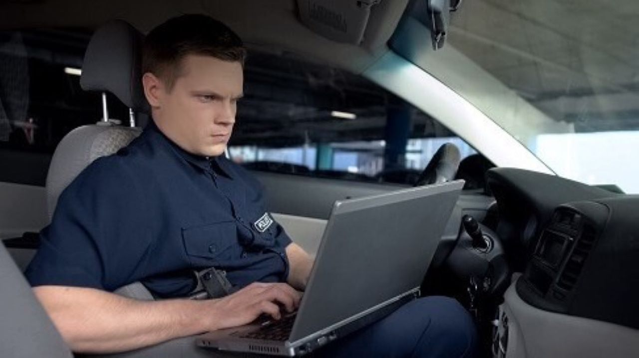 A police officer on a laptop sitting in a car A police officer on a laptop sitting in a car