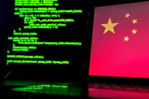 Laptop with Chinese flag onscreen and another display blurred in background