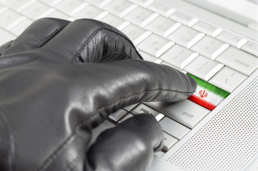 Hacking Iran concept with hand wearing black leather glove pressing enter key with flag overlaid