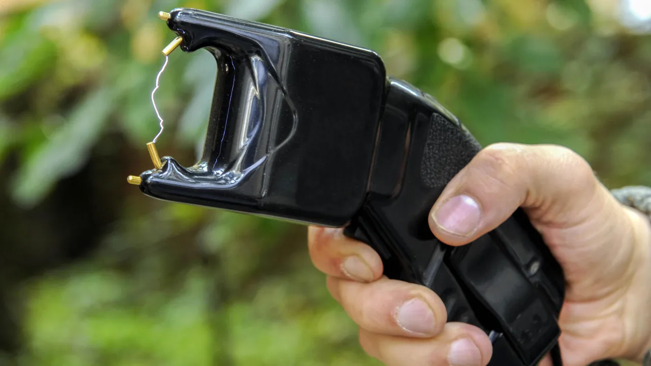 A hand holding a high voltage stun gun. A hand holding a high voltage stun gun.
