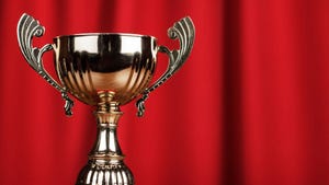 a brass two-handled trophy against a red curtain in the background. a brass two-handled trophy against a red curtain in the background.