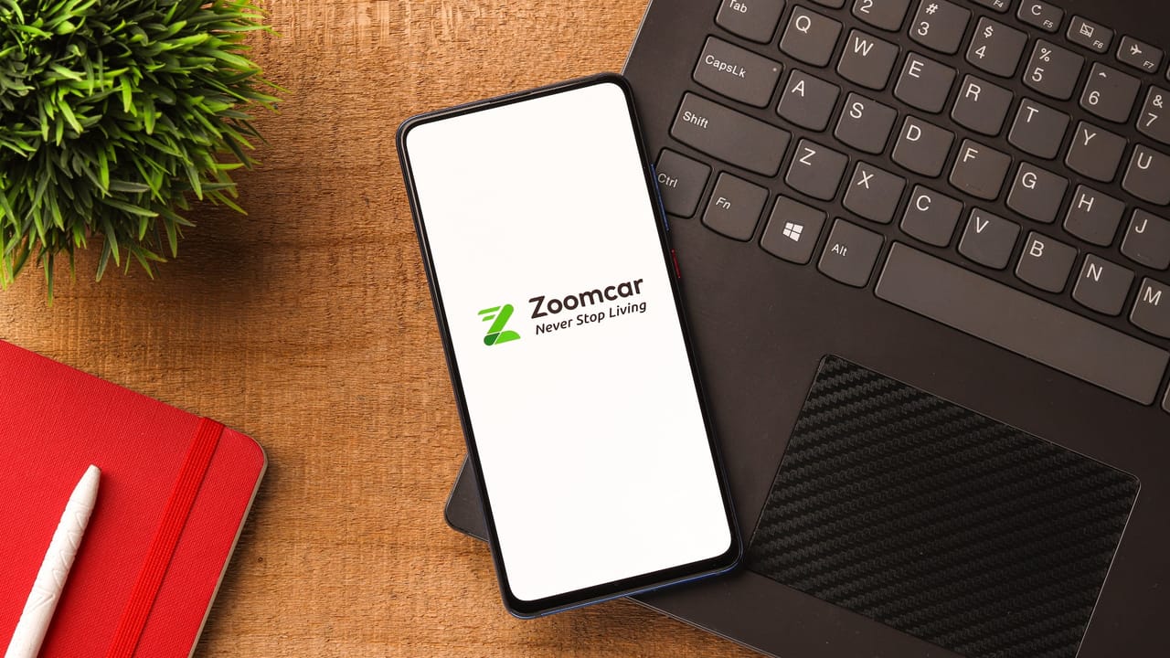 Zoomcarアプリがノートパソコン上にある携帯電話に表示されている Zoomcarアプリがノートパソコン上にある携帯電話に表示されている