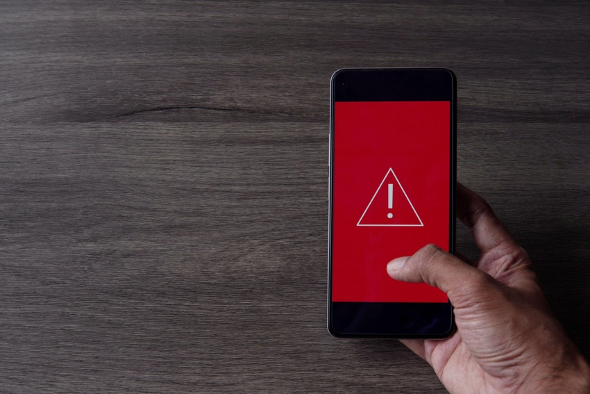 Smartphone with triangle caution warning icon on the screen