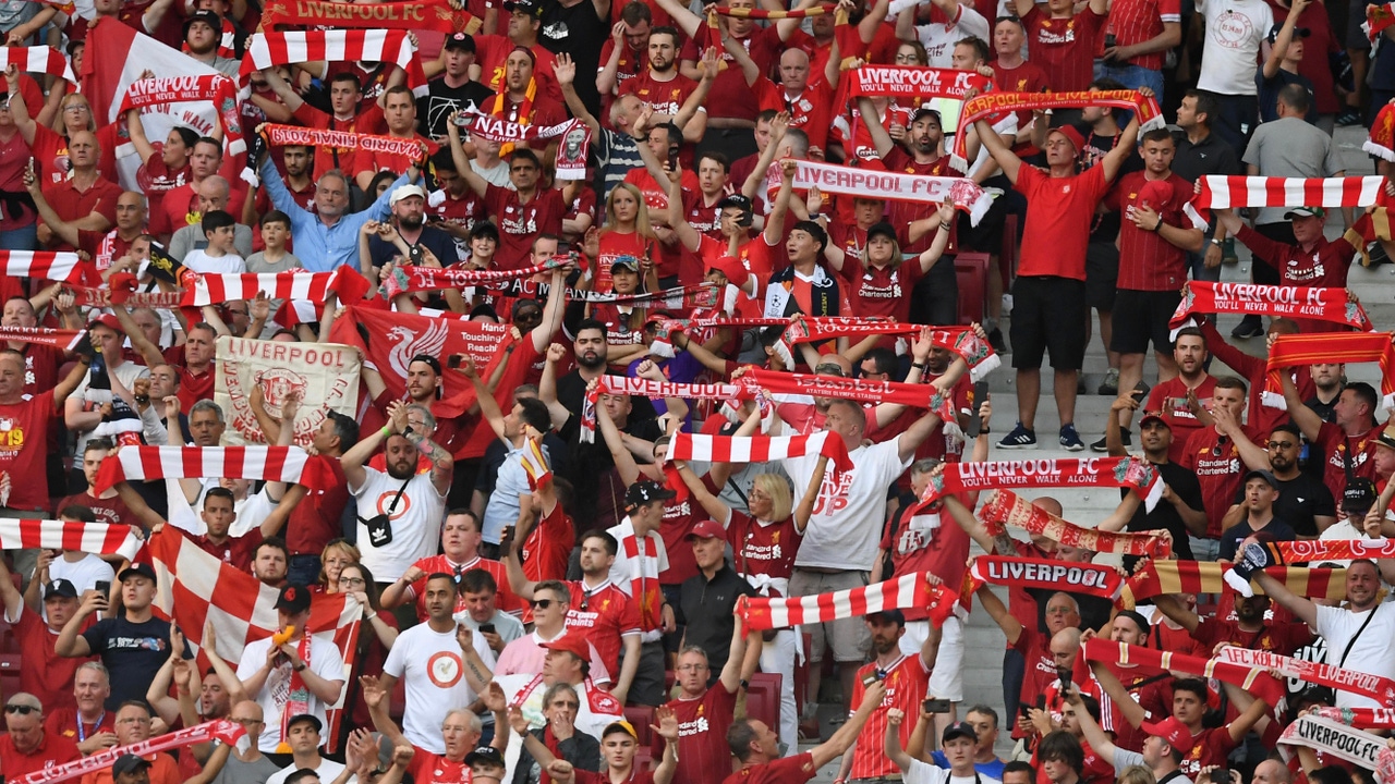 A crowd of Liverpool football fans in the stands at a game A crowd of Liverpool football fans in the stands at a game