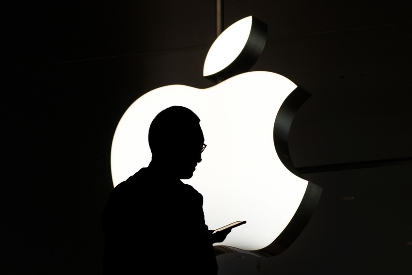 Silhouette of person in front of apple logo