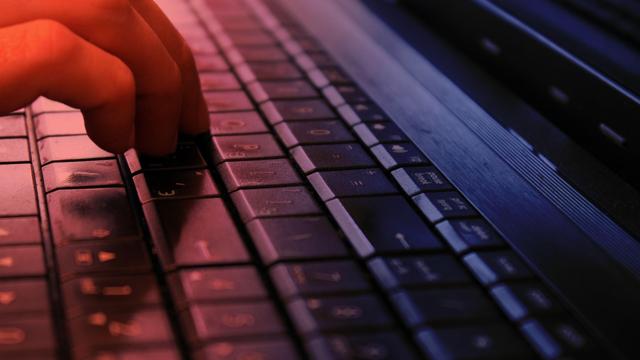 A person's hand on a computer keyboard A person's hand on a computer keyboard